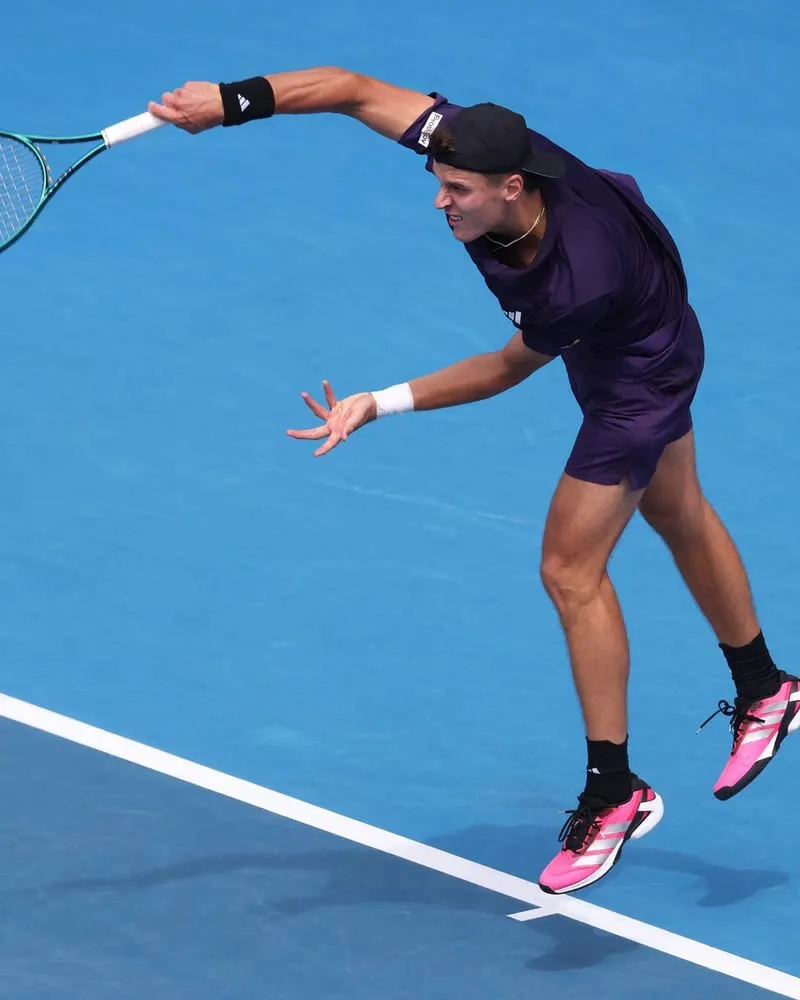 Jakub Mensik following through on a serve during a hard-court match