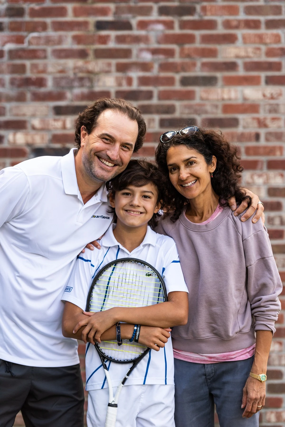 Parents with their junior player holding a racquet